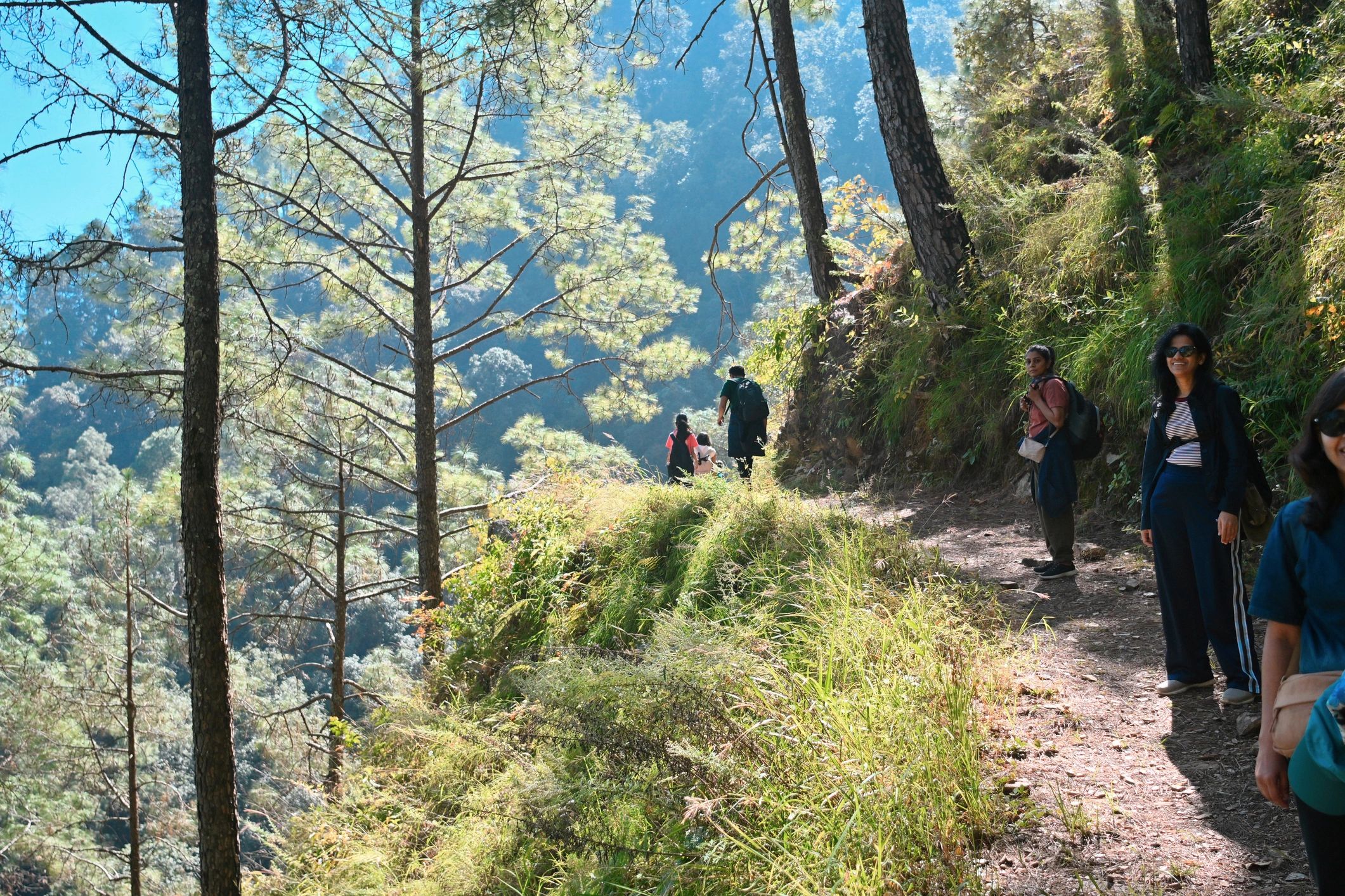 Tourists hiking a scenic mountain trail in Uttarakhand